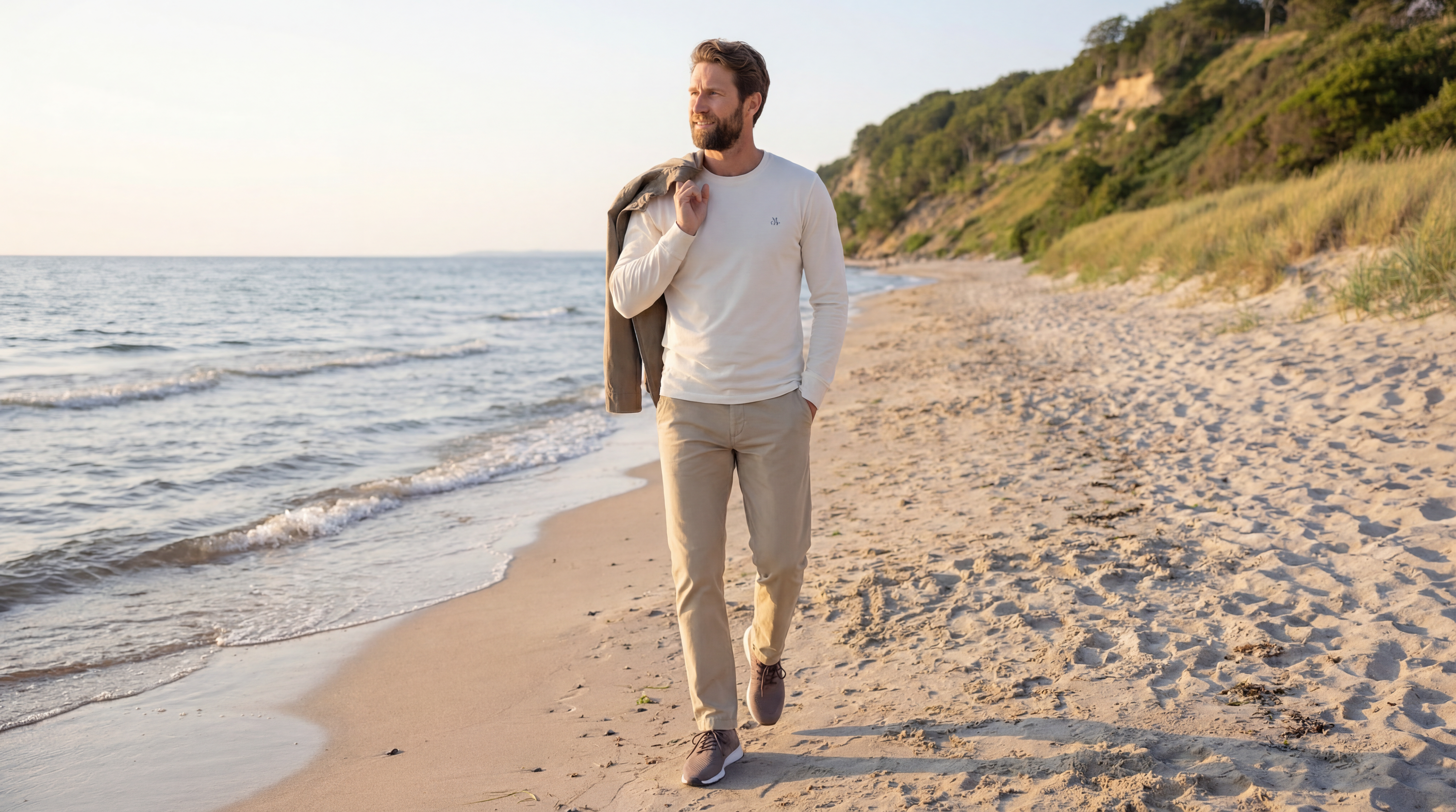 Entspannter Herren Frühlingslook von Marc O'Polo mit hellem Pullover und beiger Chino am Meer - Pier 14